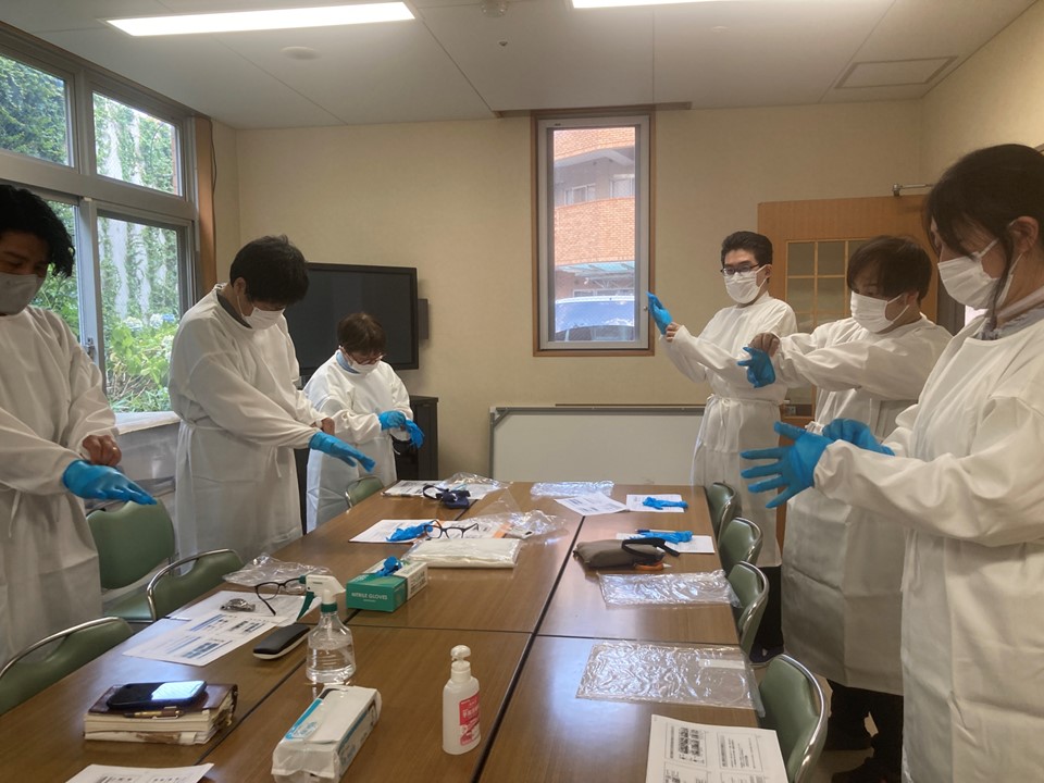適切な措置、対策が確実に行われるように職員への教育と共有のため、今日は事務所のメンバーで包括支援センターの所長の指導の下、誰でも身につくようにガウンテクニックの脱着を練習しました。<br>今までも何回か研修でやってきましたが、いざという時に誰もがスムーズに正確に行えるように真剣に行いました。<br>
