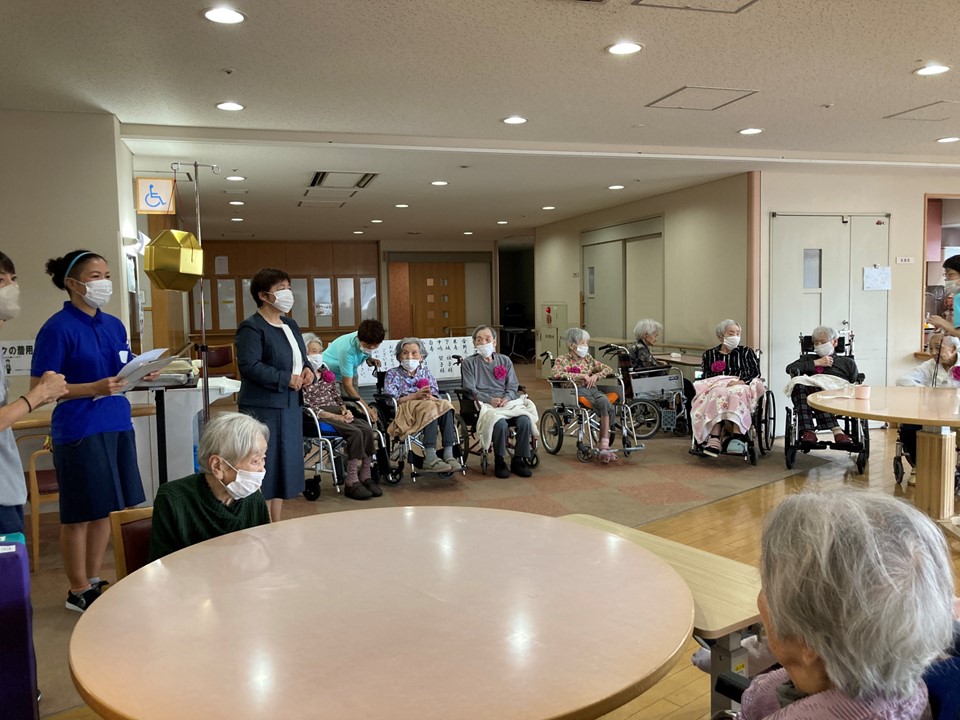 聖母ホームでは敬老の日の9月16日に敬老会を行いました。<br>特養では12名の方が施設長からお祝いの記念品をいただきました。<br>『長生きの秘訣を伺っても良いでしょうか』と<br>係りの職員がお聞きすると『特にありません』とおっしゃったので、<br>どっと笑いが起こりました。笑いが一番です。<br>
